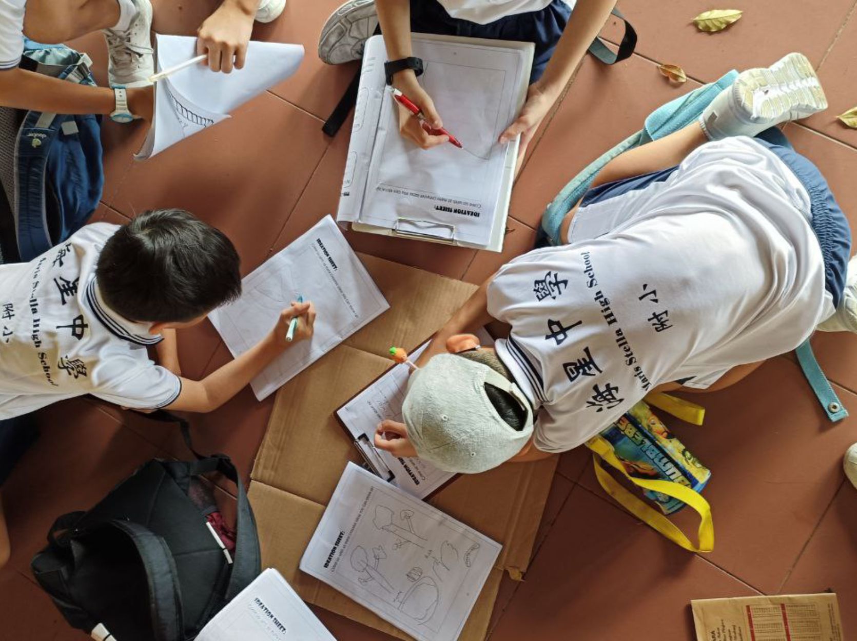 Students writing on the floor
